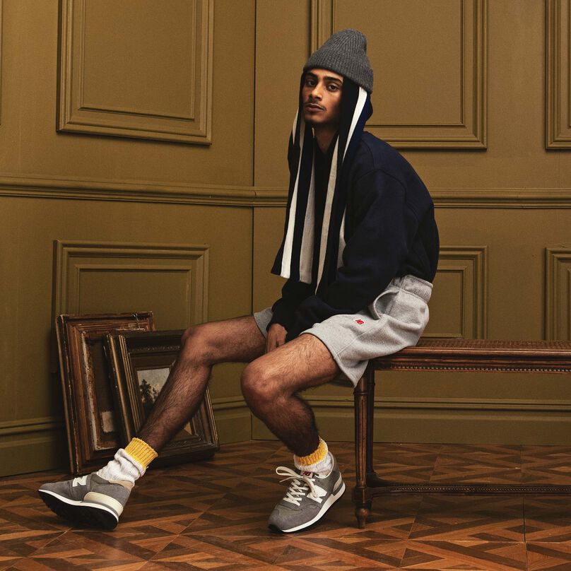 Man sitting on a wood bench in a beautiful indoor environment wearing MADE in USA apparel and footwear.