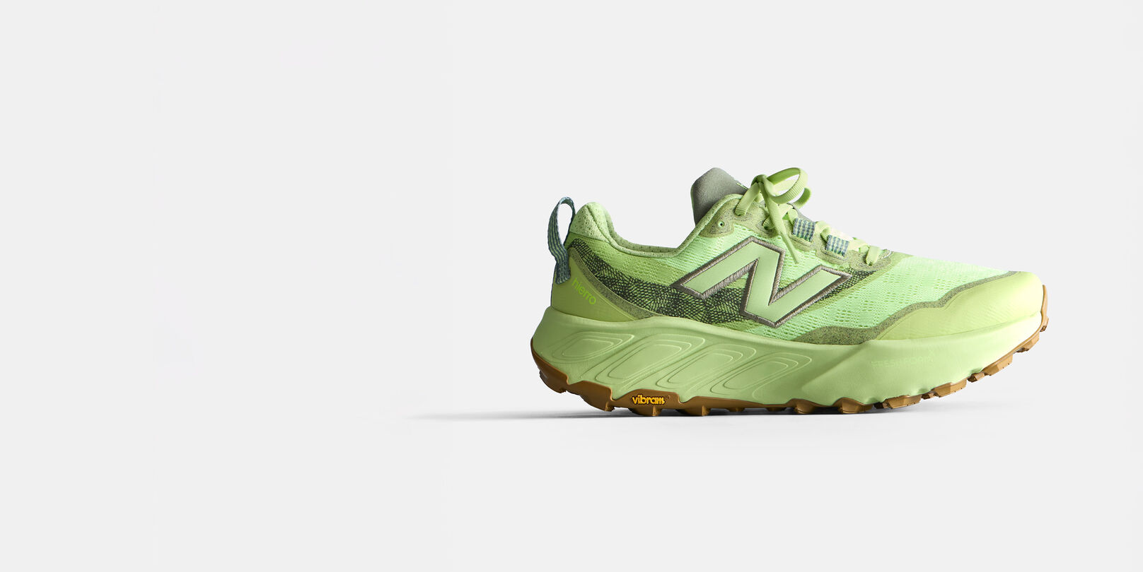 Light green sneaker with a thick sole and a New Balance logo, shown on a white background. 