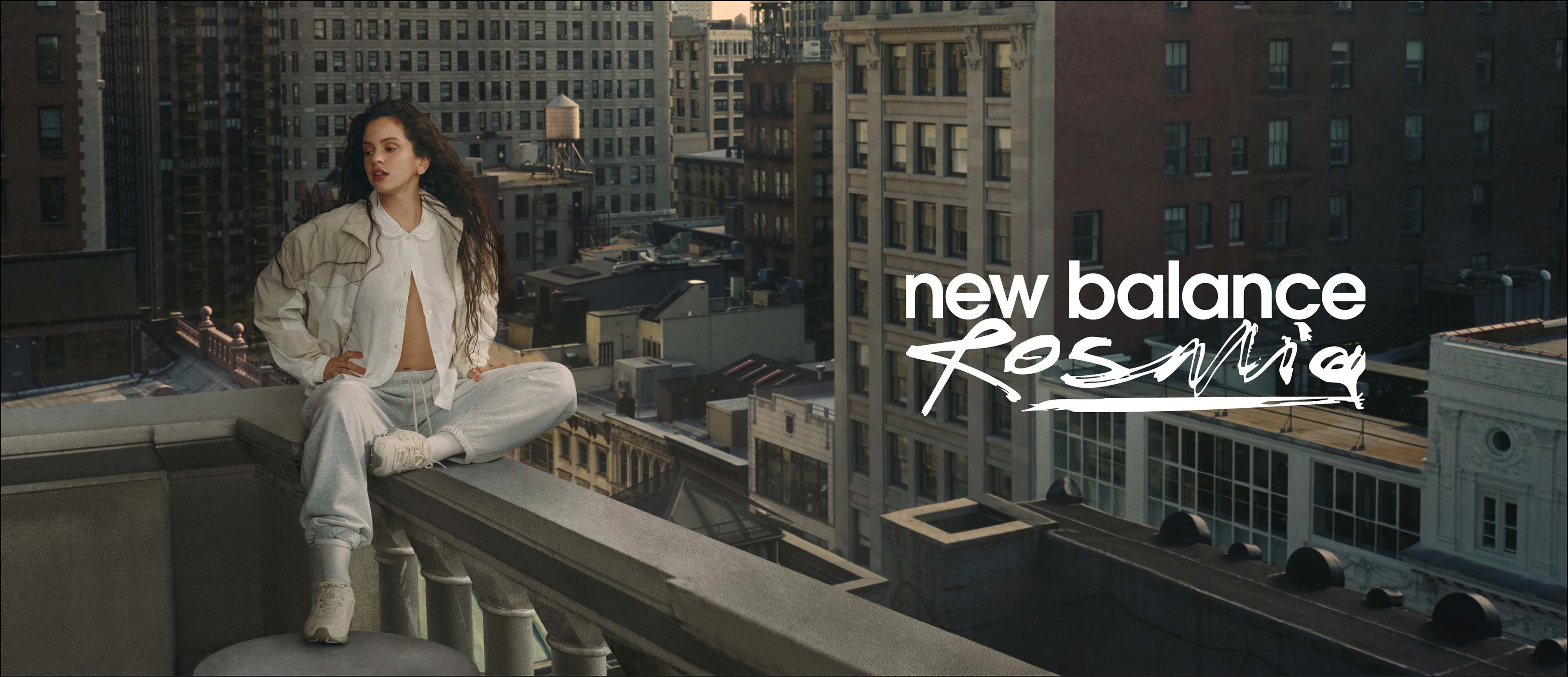 Rosalía sitting on a balcony overlooking the city.