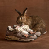 A pair of New Balance Made in UK sneakers sitting on a concrete floor.